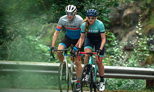 Man en vrouw rijden op cyclocross racefietsen op de weg.