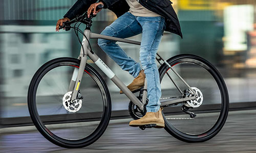 Een fietser rijdt op zijn fitnessfiets door de stad, de fietser is slechts gedeeltelijk zichtbaar.