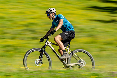 Fietser met blauw T-shirt en helm op een Cube Reaction mountainbike hardtail.