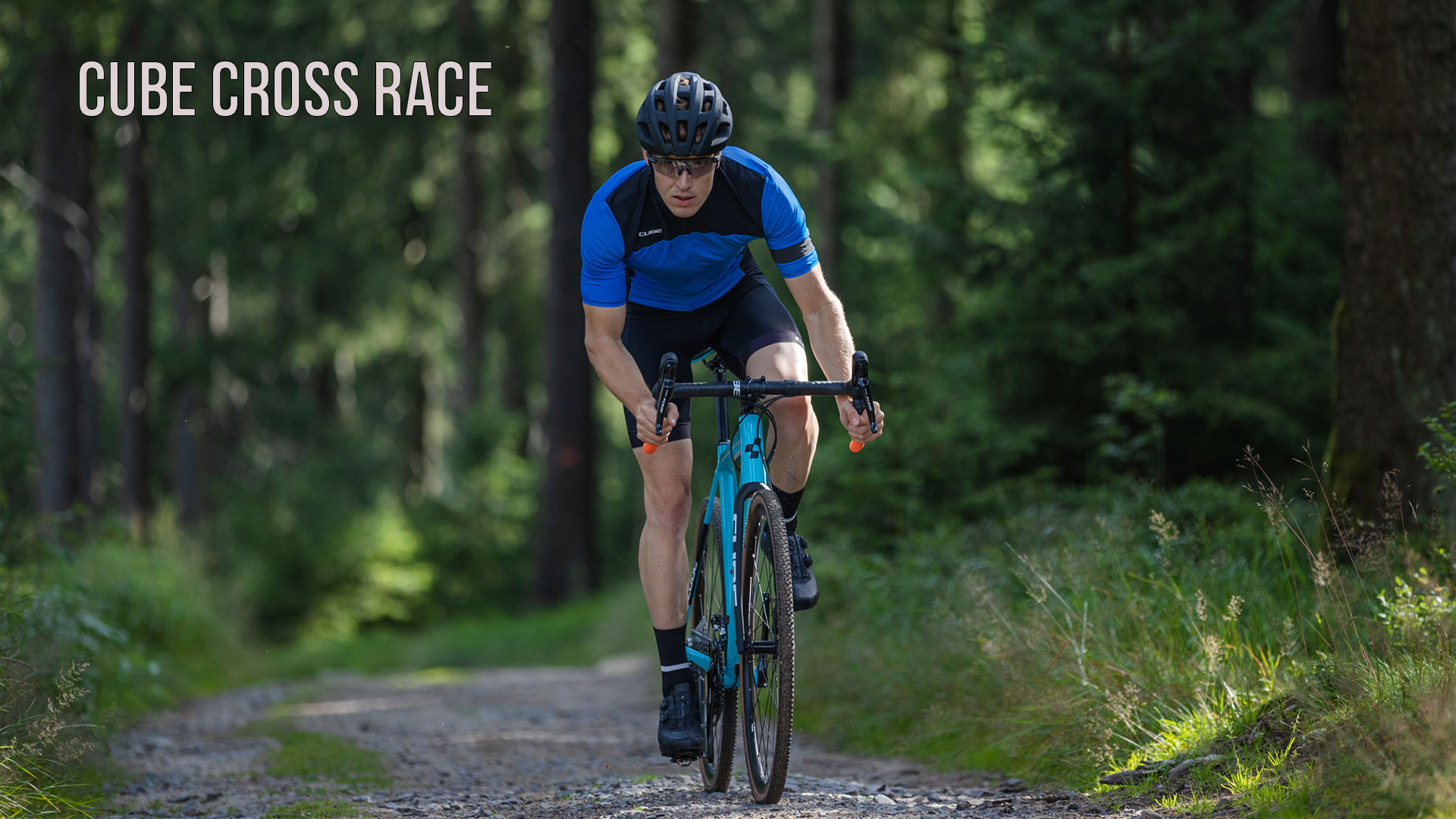 Een man rijdt op een Cube Cross Race-fiets door het bos.