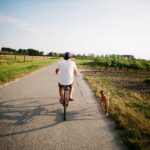 Man fietst naast zijn hond &ndash; samen veilig fietsen met hond.