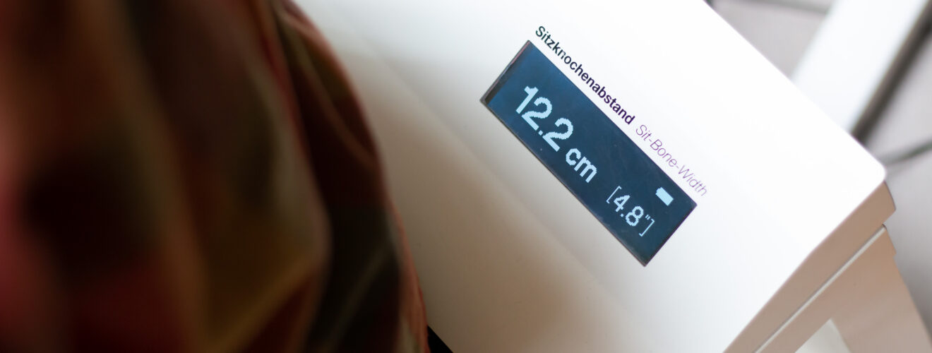Meetapparaat toont zitbotafstand van 12,2 cm op display.