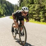 Man op een aero racefiets in diepe zithouding, met gestroomlijnde kleding en helm Man op een aero racefiets in diepe zithouding, met gestroomlijnde kleding en helm