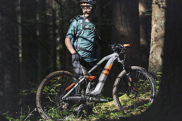 De topklasse Man naast een e-mountainbike in het bos