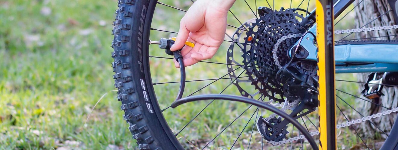 Fietspomp wordt aangesloten op ventiel – optimale bandenspanning mountainbike instellen.
