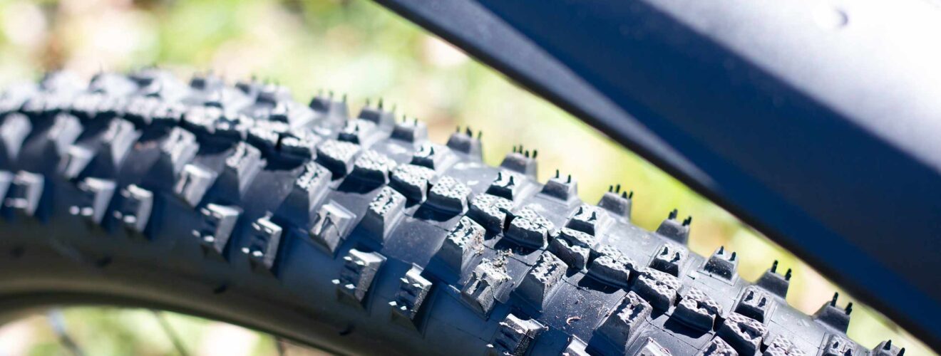 Close-up van MTB banden met grof profiel – optimale grip voor ruig terrein.