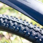 Close-up van MTB banden met grof profiel – optimale grip voor ruig terrein. Close-up van MTB banden met grof profiel – optimale grip voor ruig terrein.