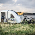 Wide Path Camper achter een fiets op de weg Wide Path Camper achter een fiets op de weg