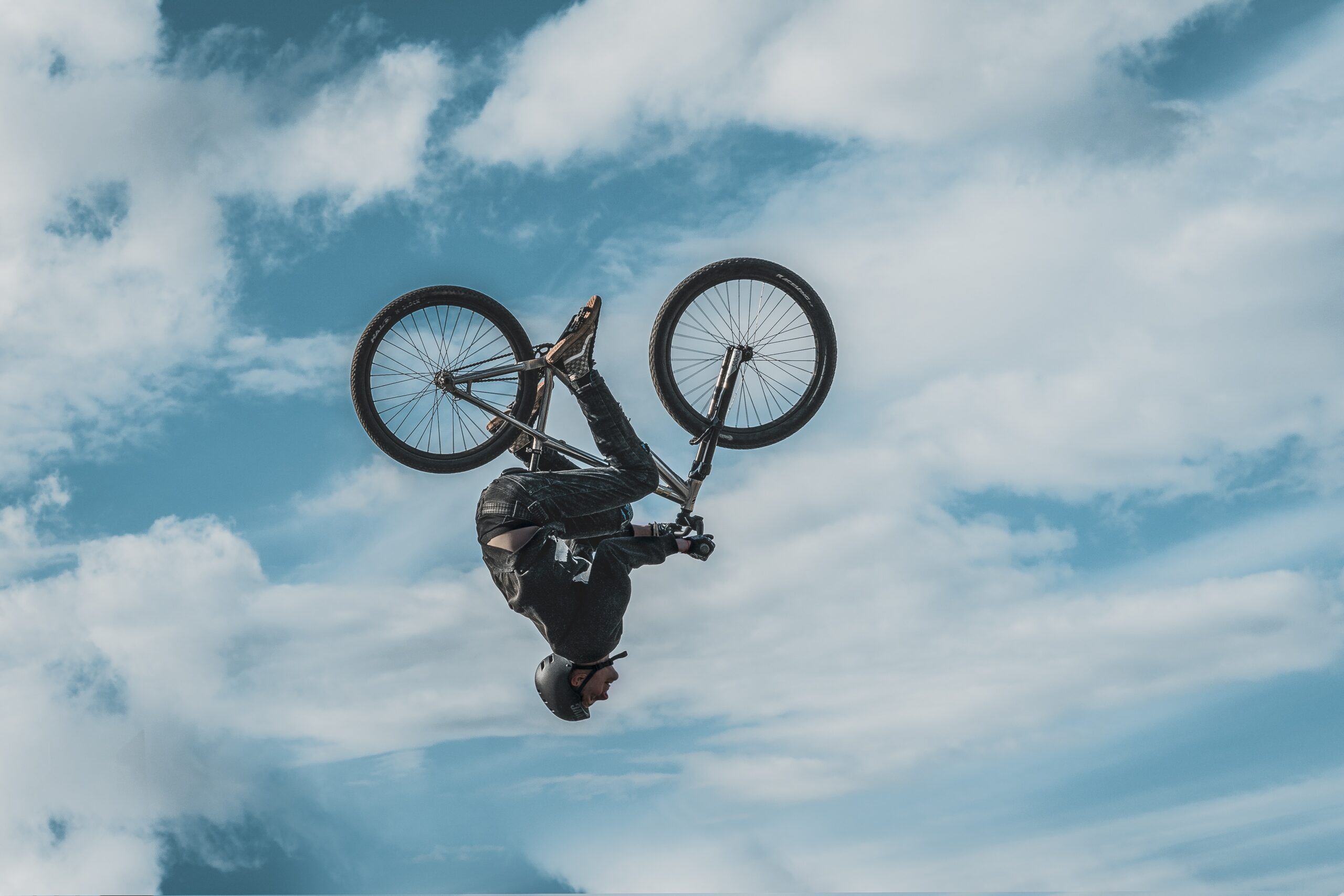 Fiets met rijder op zijn kop in de lucht, mogelijk omgekeerd door een stunt of val Fiets met rijder op zijn kop in de lucht, mogelijk omgekeerd door een stunt of val
