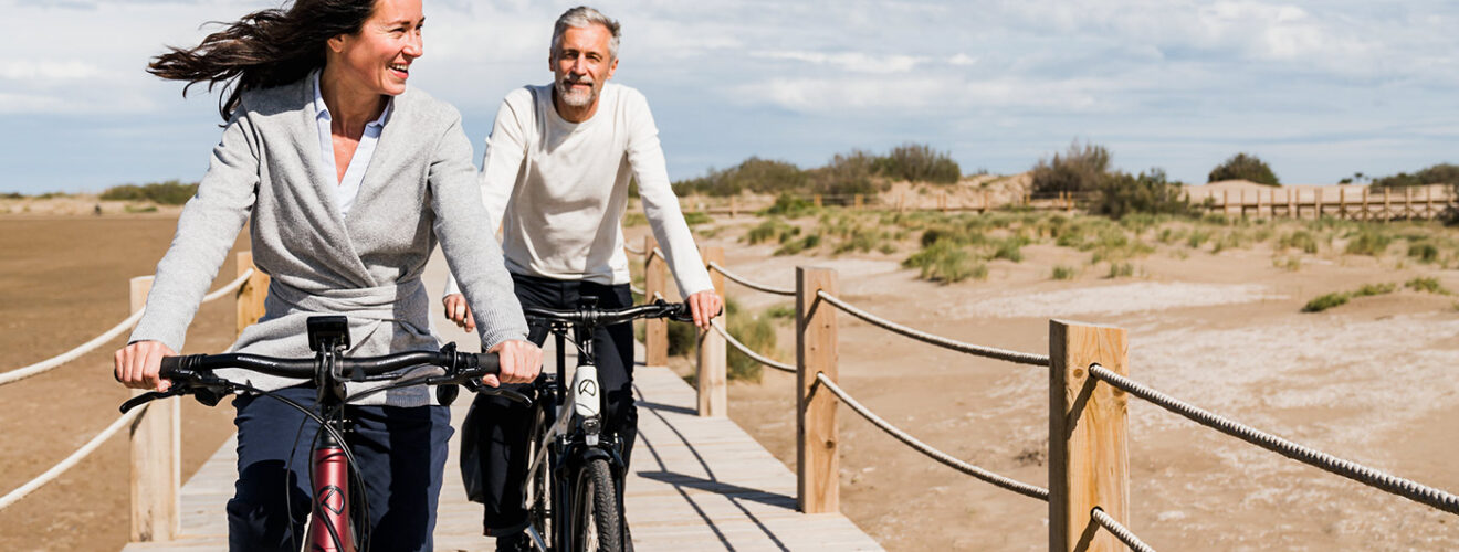 Man en vrouw fietsen samen, letten op zithouding om klachten tijdens het fietsen te voorkomen