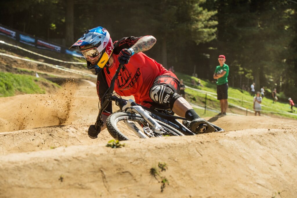 Man op een dirtbike met helm en bril in een bikepark Man op een dirtbike met helm en bril in een bikepark