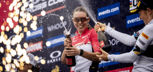 Kira Böhm viert haar overwinning in Canada op het podium door een geopende fles champagne te laten spuiten, naast een andere vrouwelijke deelnemer.