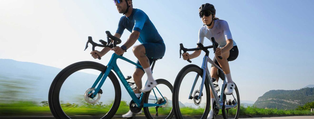 Fietser en fietsster op een Cube racefiets 2026 tijdens het rijden.