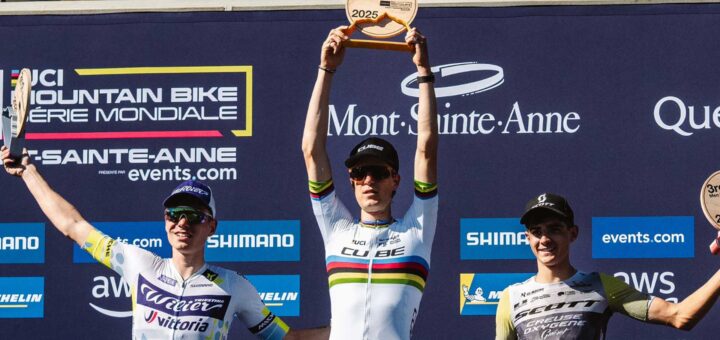 Finn Treudler viert de Cube Factory Racing-seizoensfinale 2025 in Mont-Sainte-Anne met de trofee in zijn handen, geflankeerd door de tweede en derde plaats op het podium.